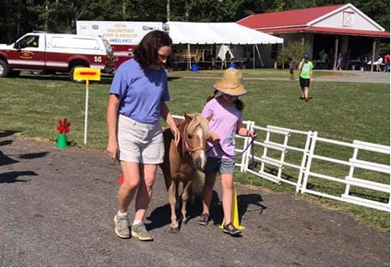 Mini horse with child at Camp Fantastic