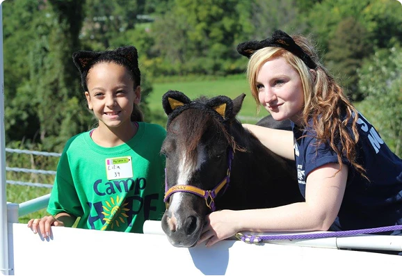 Two children petting a miniature horse